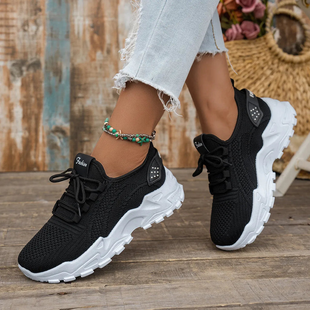 Women's white Flyknit mesh casual sports shoes with flat heel and lace-up front on a neutral background.