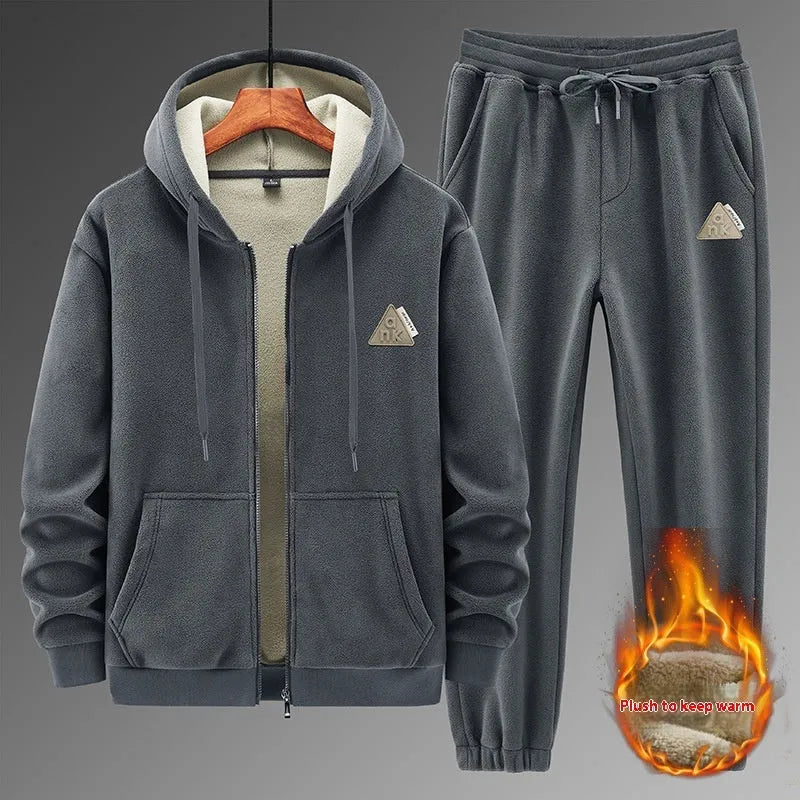 Man wearing a grey hooded cashmere sweater and matching cotton trousers from a casual sports suit set.