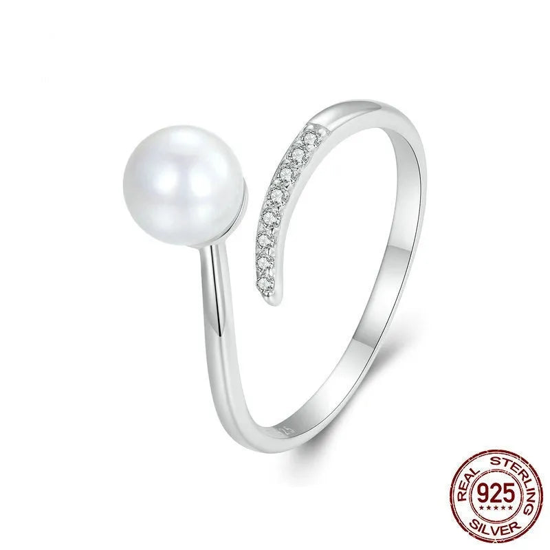 Silver adjustable open loop ring with shell pearls on white background