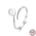 Silver adjustable open loop ring with shell pearls on white background