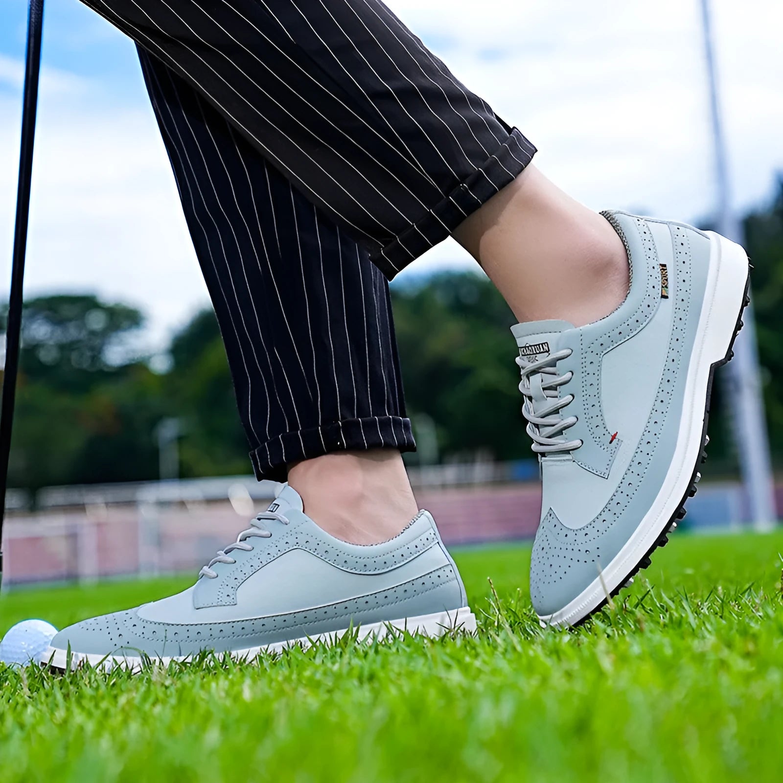 Men's Lake Blue genuine leather golf shoe with non-slip rubber sole on a golf course.