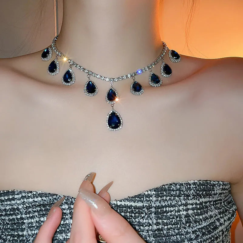 Silver needle water drop earrings and necklace set with blue zircon pendants and love heart bell pattern on white background