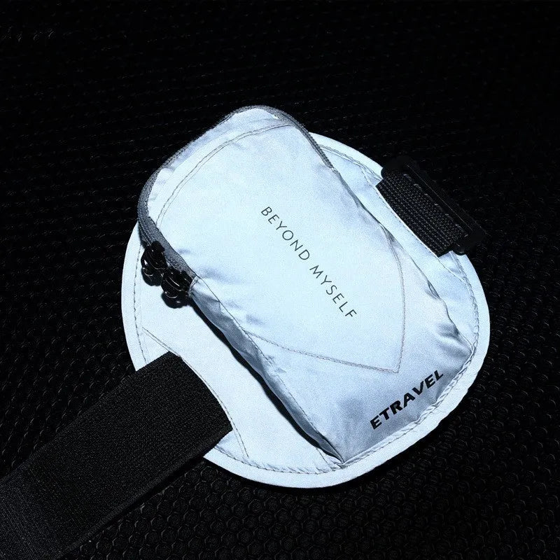 Reflective black running arm bag with adjustable strap shown on an arm.
