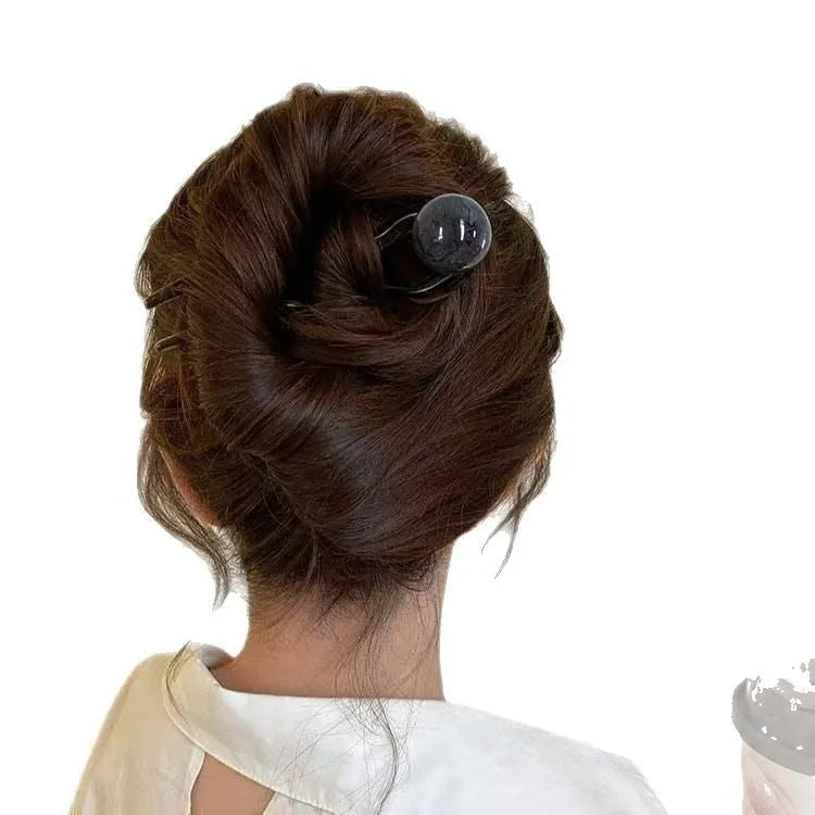 A set of simple U-shaped acrylic hair barrettes with a retro ball detail in beige and caramel colours.
