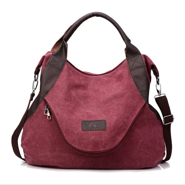 Women's canvas handbag in lake blue with zipper closure, hard handle, and double strap roots for shoulder or crossbody carry