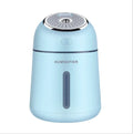 Mini ultrasonic humidifier 330ml four-in-one USB with LED light and fan in blue, pink and white on desk