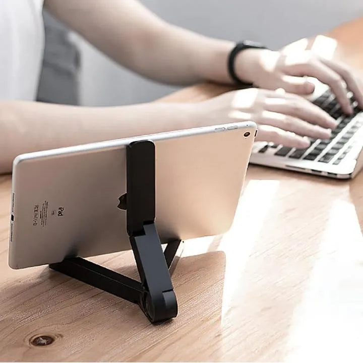 Black foldable tablet holder supporting a tablet in landscape viewing position on a desk