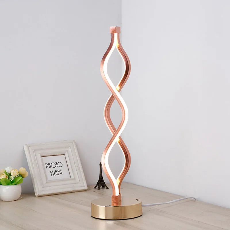 Gold LED desk lamp with acrylic shade and aluminium body on a desk