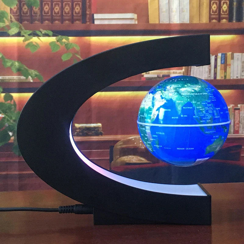 Magnetic levitation globe floating above base with LED light on
