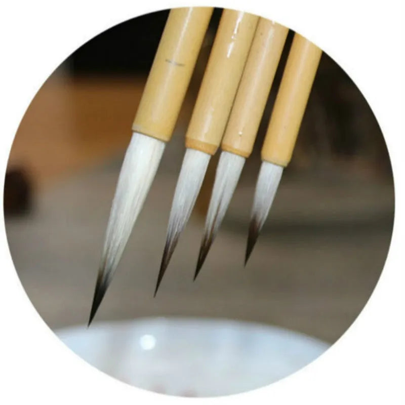 Set of four gold-coloured writing brushes with mixed hair bristles for calligraphy.