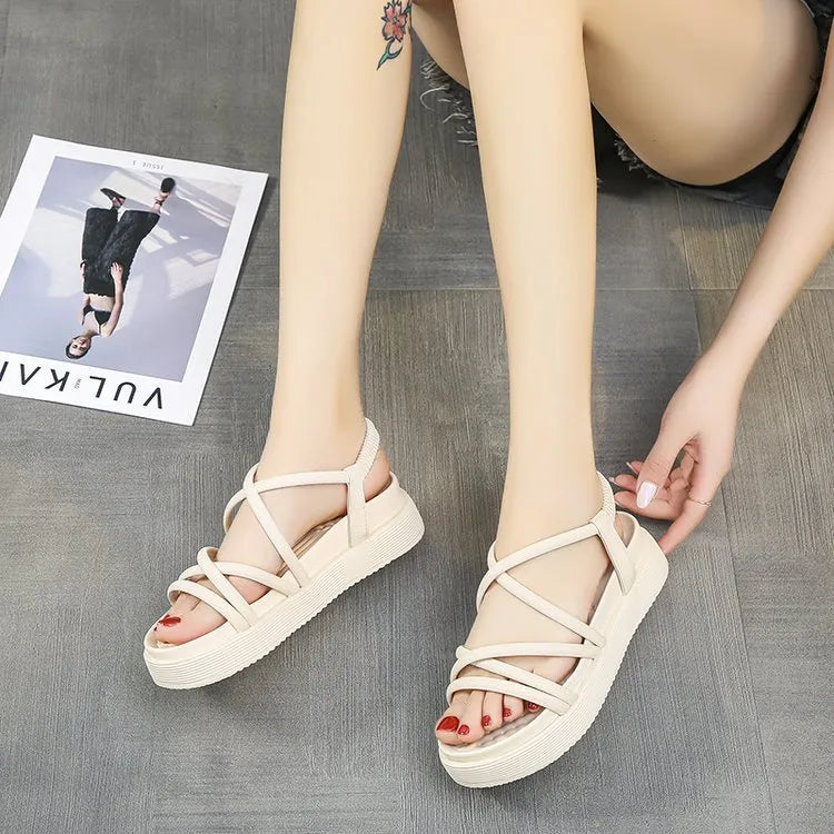 Women's black and beige Roman-style platform sandals with a round toe holder on a textured sole.