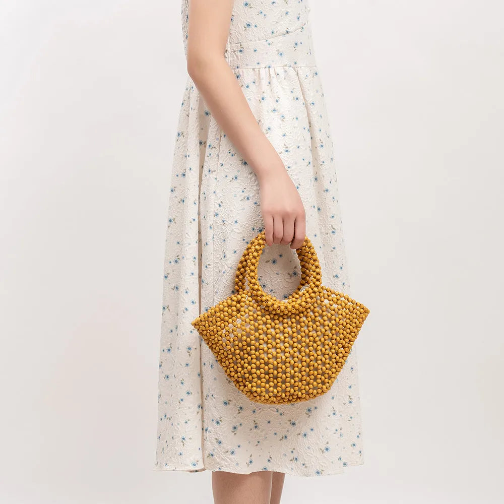 Maple wood woven dumpling-shaped handbag with wooden bead decoration, shown in milky white.