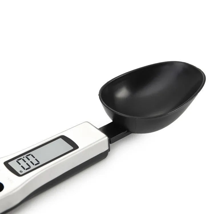 Smart digital kitchen measuring spoon with backlit LCD display showing weight and volume measurements.