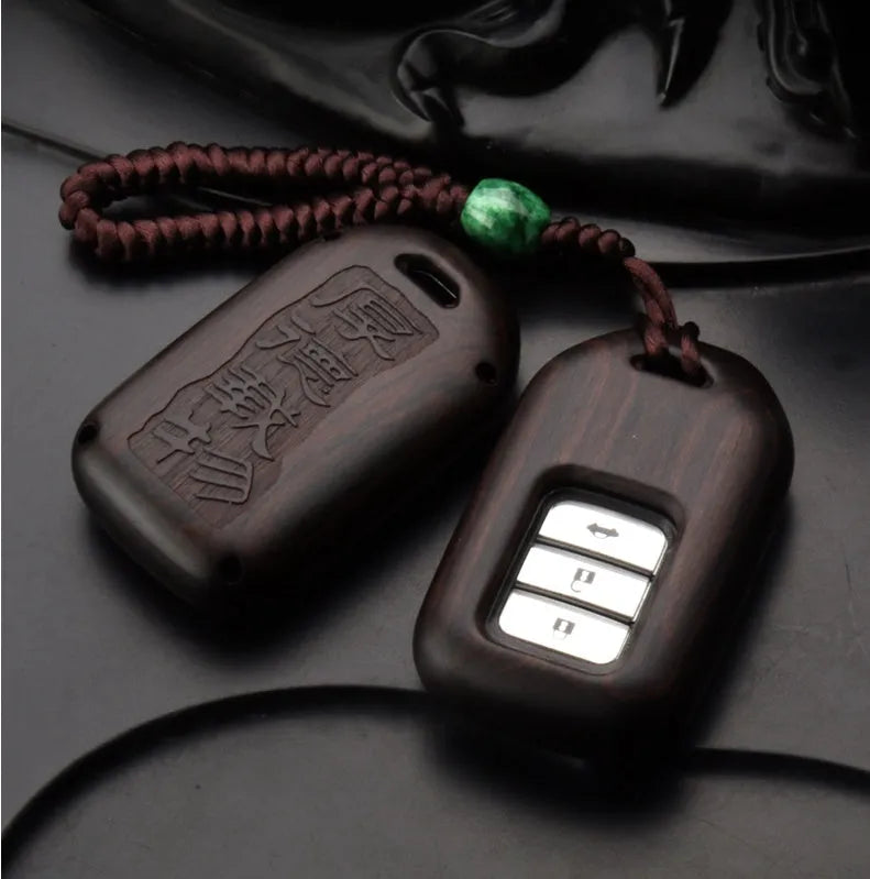 Solid ebony sandalwood key case with key rings, showing carved wood grain on a plain background