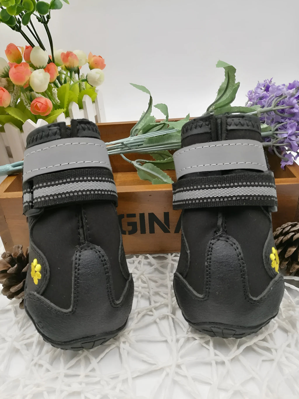 Black dog shoes with waterproof PVC sole and adjustable fuzzy belt on a white background