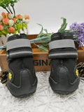 Black dog shoes with waterproof PVC sole and adjustable fuzzy belt on a white background
