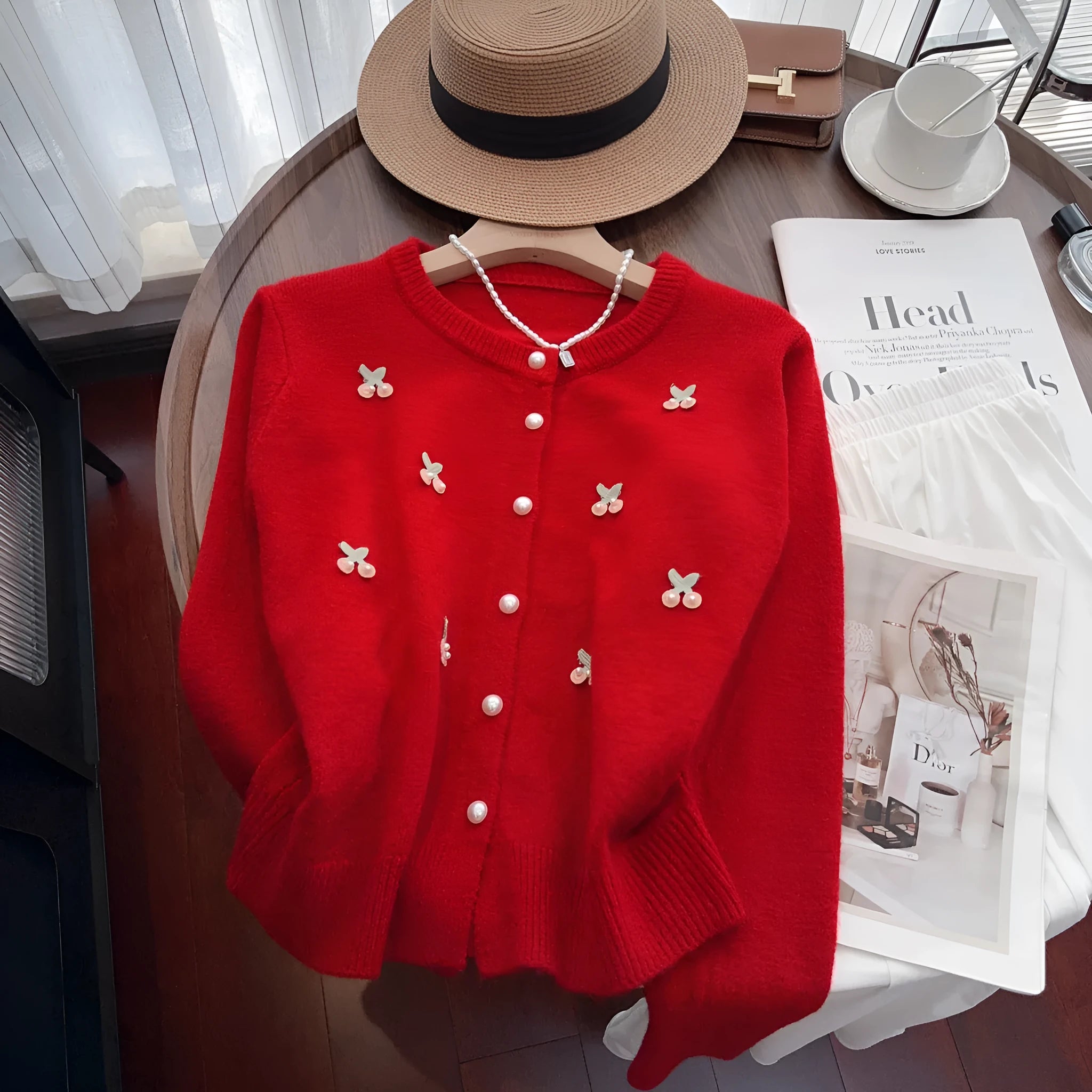 Women's soft pink cashmere blend cardigan coat with beaded detail and round neck, laid flat.