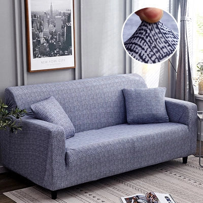 Printed stretchable sofa slipcover covering a three-seater sofa in a modern geometric pattern