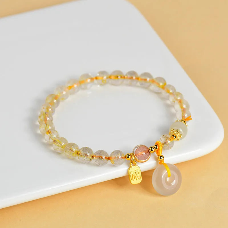 Gold rutilated quartz crystal bracelet with peace buckle closure and blessing card pendant
