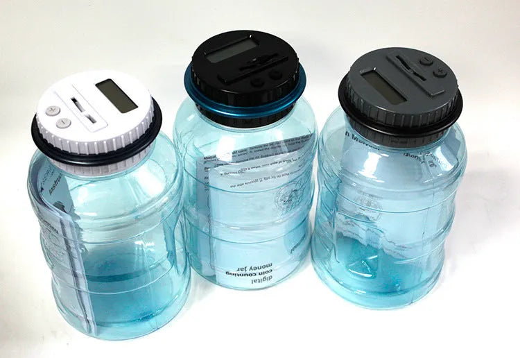 Transparent digital coin counting money box with LCD screen on lid, showing coin slot and clear jar body