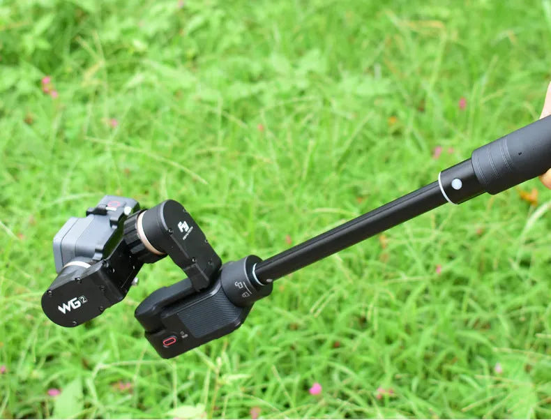 Black retractable aluminium selfie stick extended, with a smartphone mounted on the holder.