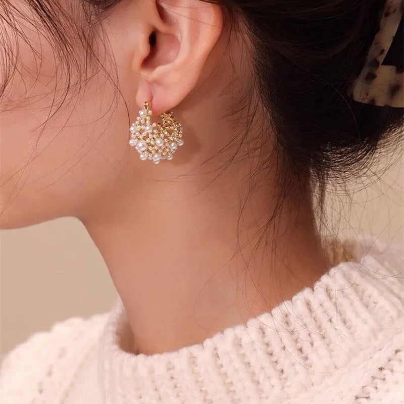 Gold-coloured copper flower basket earrings with small rice-shaped beads and pearl inlay details