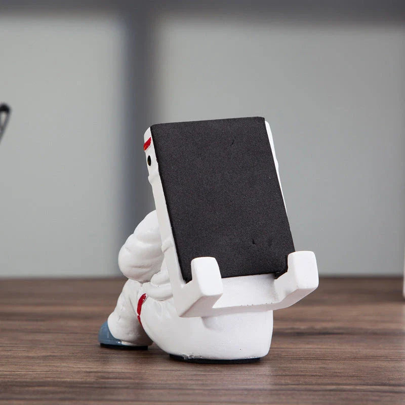 Astronaut-themed resin phone stand with unique design for desk decoration