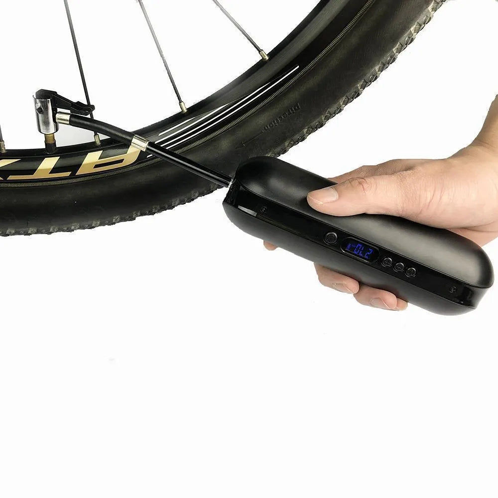 White portable electric tyre inflator with accessories on a non-slip mat, showing compact size and USB cable
