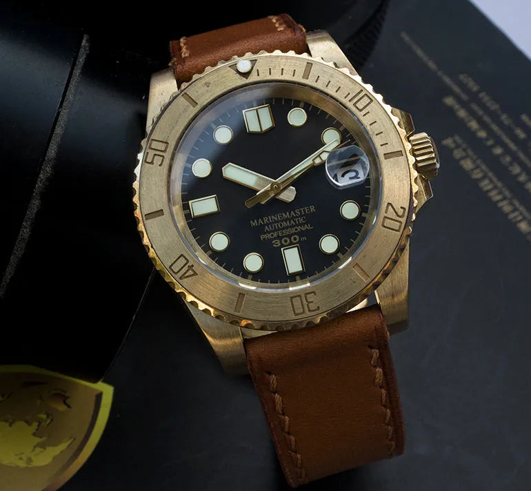 Men's vintage bronze automatic diving watch with gold dial and genuine leather strap on a wooden surface