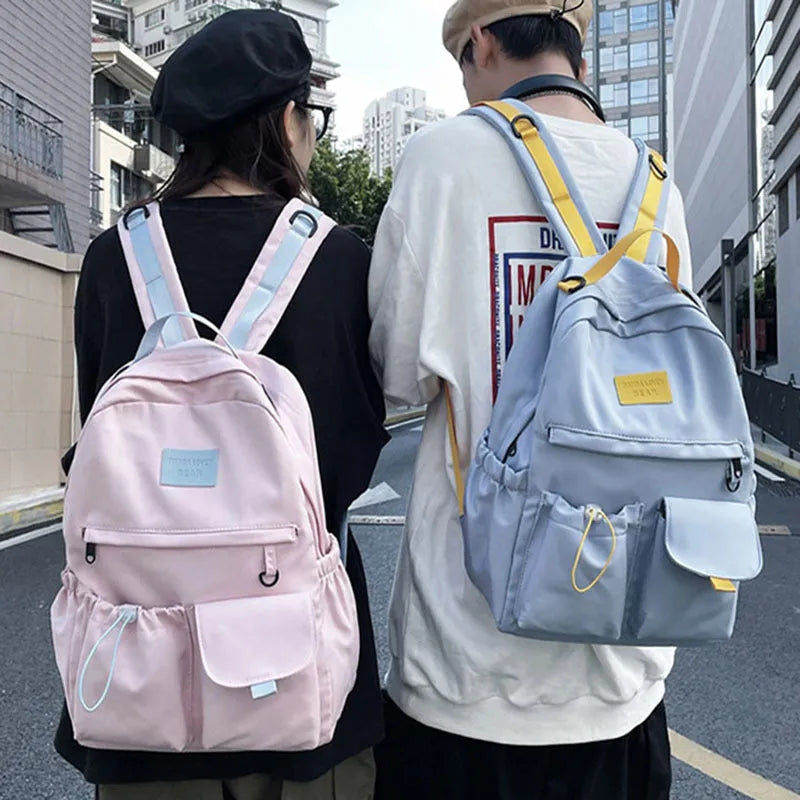 Nylon backpack school bag for junior high students, waterproof, lightweight, available in black, blue, pink, and white colours