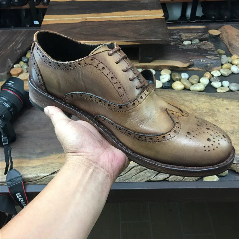 Men's light brown vintage distressed leather shoes with carved detail and round toe.
