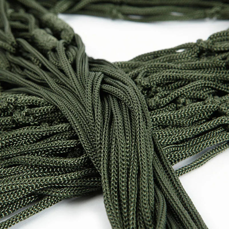 Outdoor Supplies 9-strand nylon rope hammock in red hanging between trees in a garden