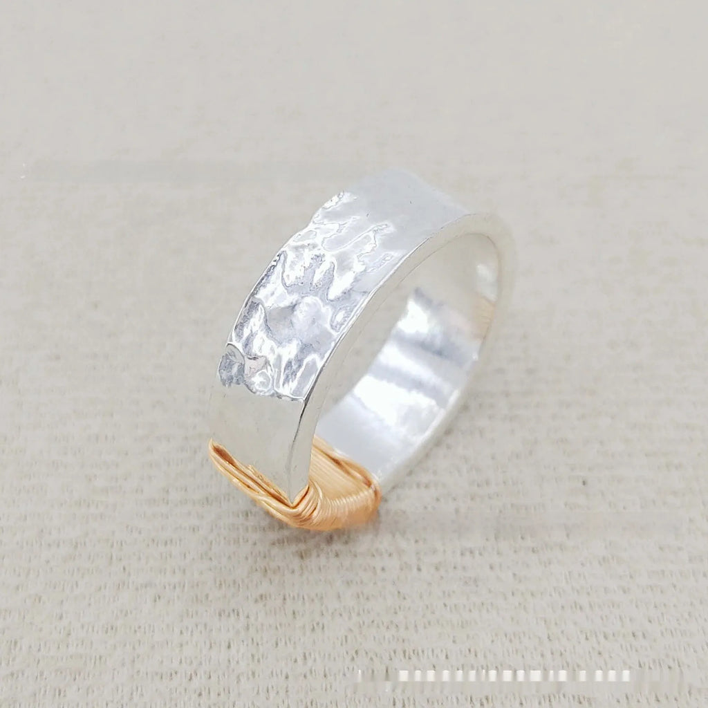 Silver golden geometric coil copper ring for men and women on a grey background.