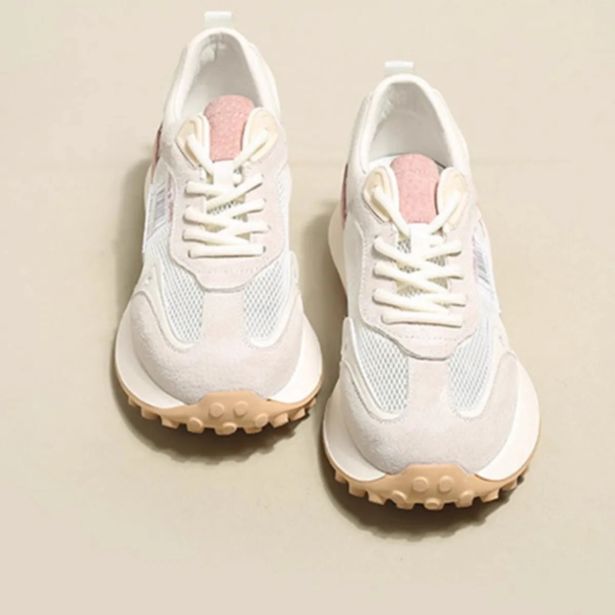 Women's low-top retro sneaker in grey or pink with round toe and rubber sole.