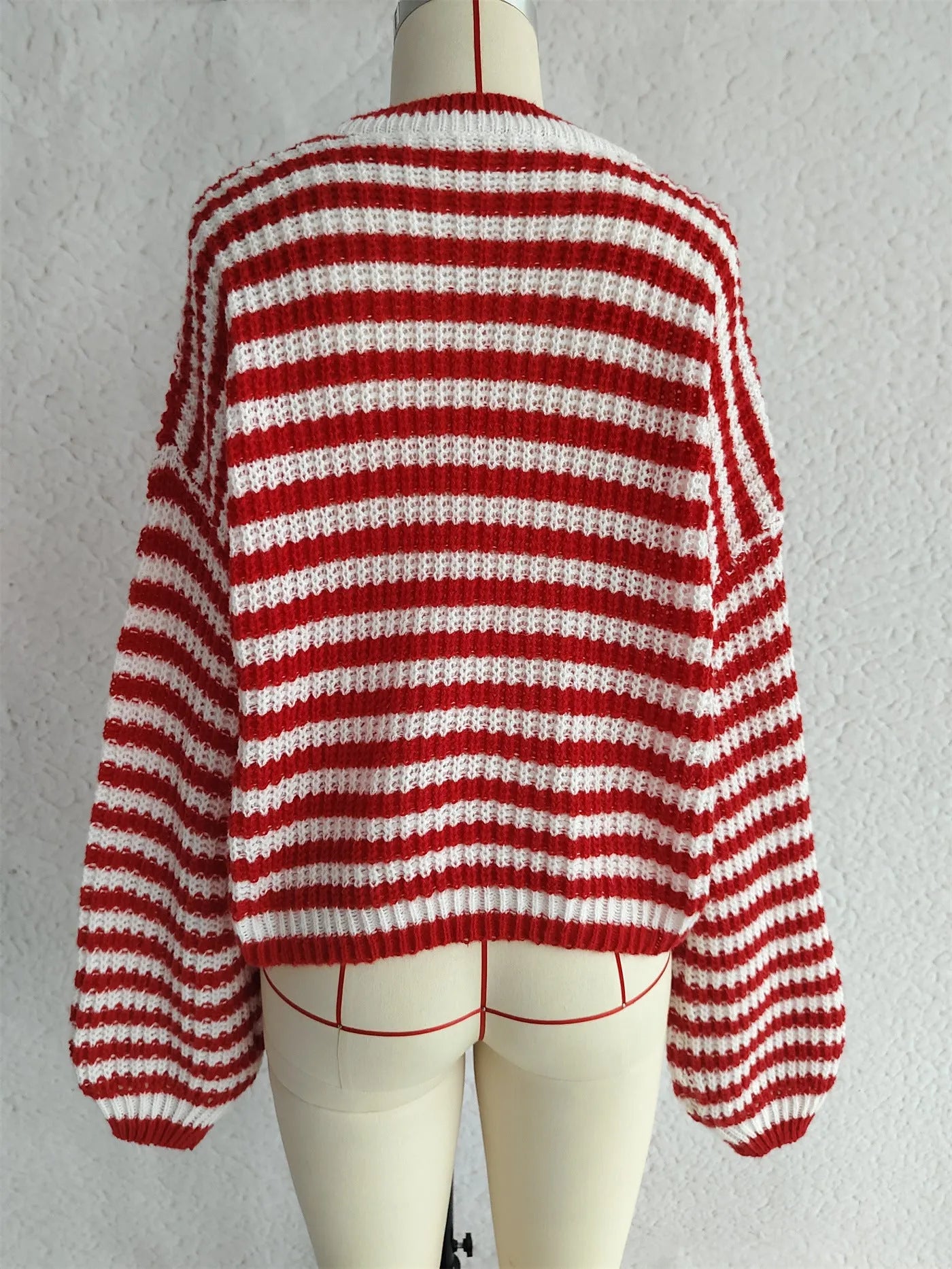 Woman wearing a black and white vintage stripe loose pullover sweater with a round neck and long sleeves.