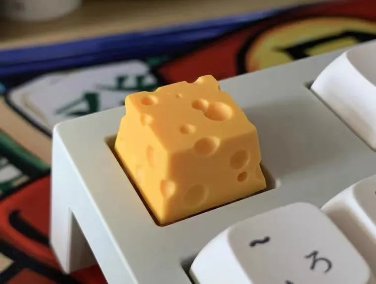 Yellow resin artisan keycap with a three-dimensional cheese design for mechanical keyboards.