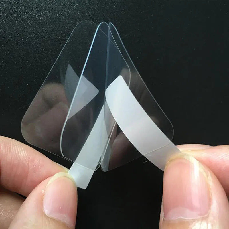 Three transparent PET screen protector films for Ticwatch2 smartwatch on a clean surface.