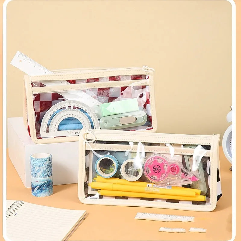 Transparent PVC pencil case showing internal chessboard grid pattern, measuring 21.5cm long.