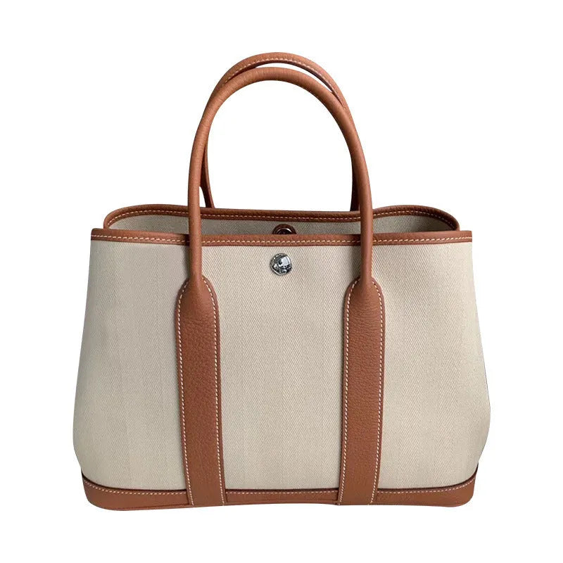 Women's canvas crossbody tote bag with leather trim in bucket style showing interior organisation pockets