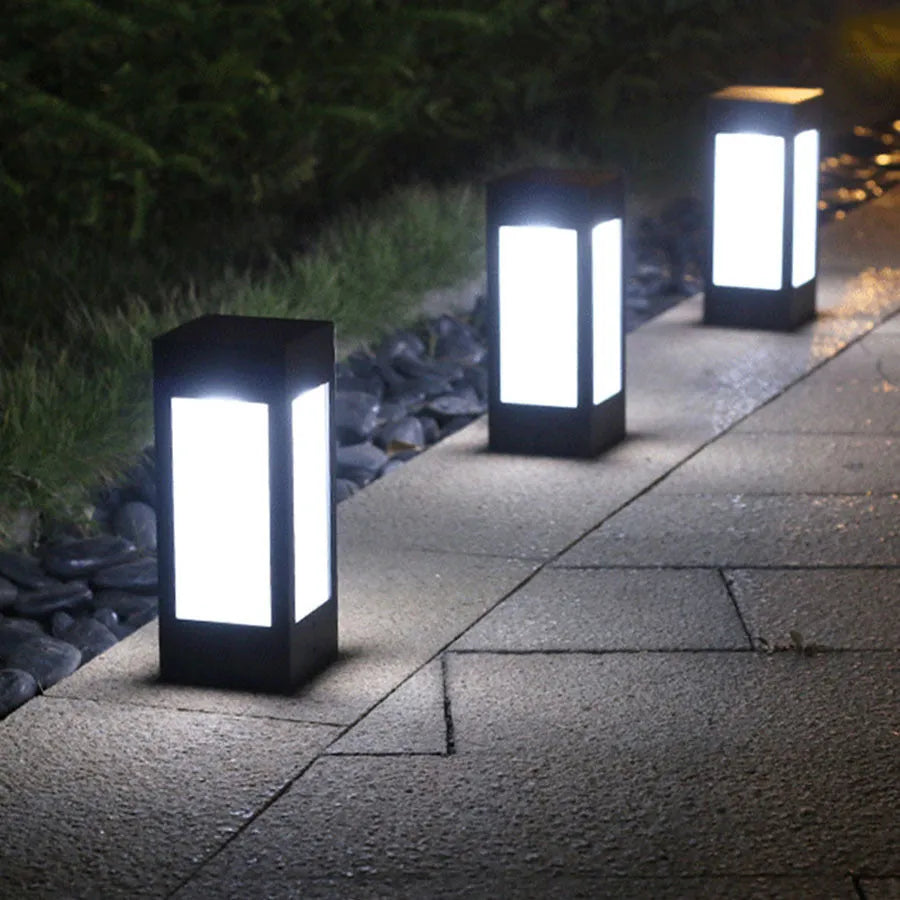 Solar-powered waterproof garden light installed on a lawn post providing white LED illumination.