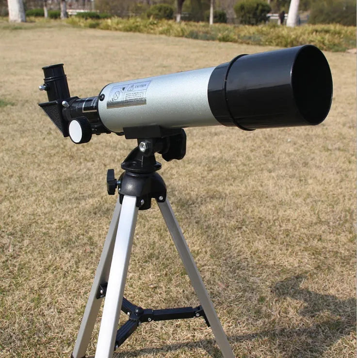 Silver telescope on aluminium tripod with multiple eyepieces and moon lens for stargazing