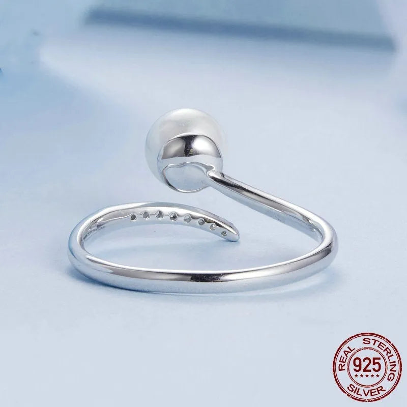 Silver adjustable open loop ring with shell pearls on white background