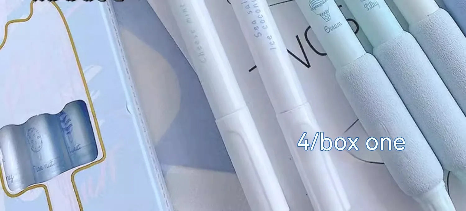 Set of four double-headed fluorescent pens for student calligraphy practice on a desk.