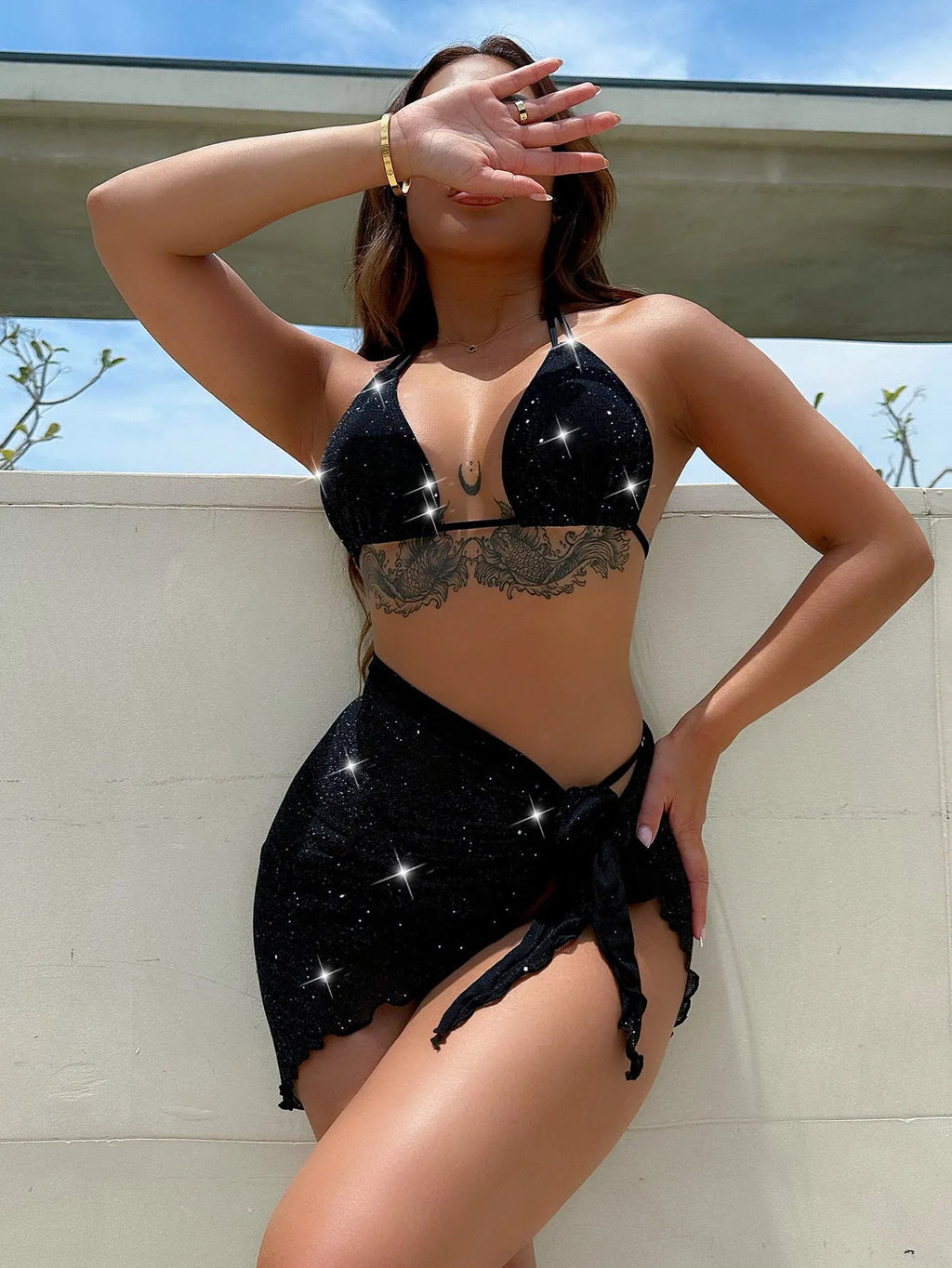 Black three-piece bikini swimsuit set with top and shorts on a mannequin.