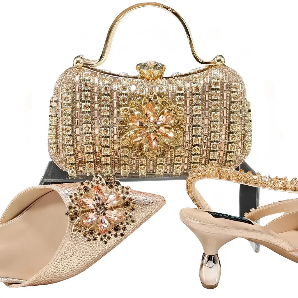 Women's black high heel and clutch bag set with rhinestone ankle chain and floral metal decoration.