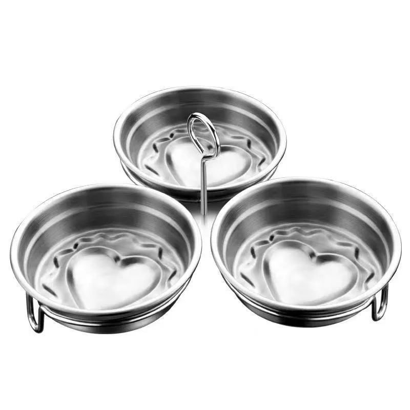 Mini stainless steel heart-shaped egg steamer for cooking soft-boiled or poached eggs on a stove.