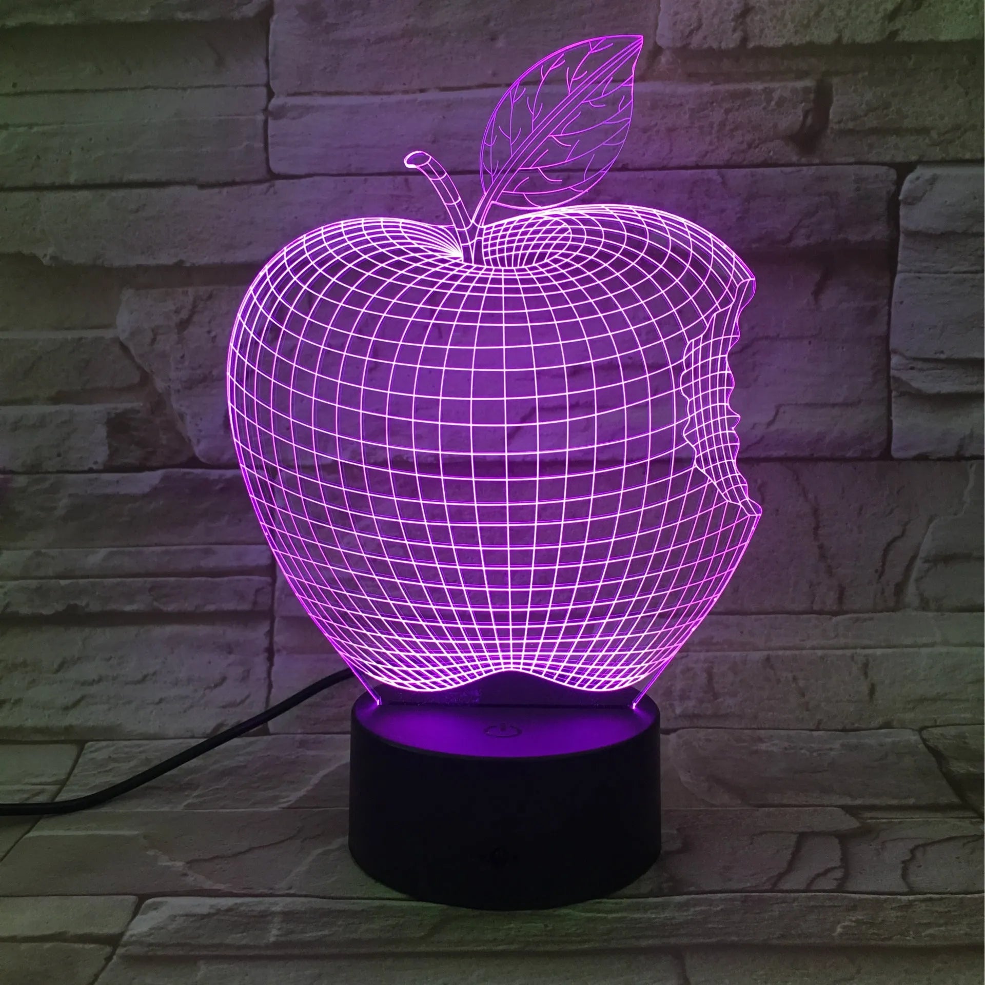 3D fruit-shaped colourful LED night light with touch control on a surface.