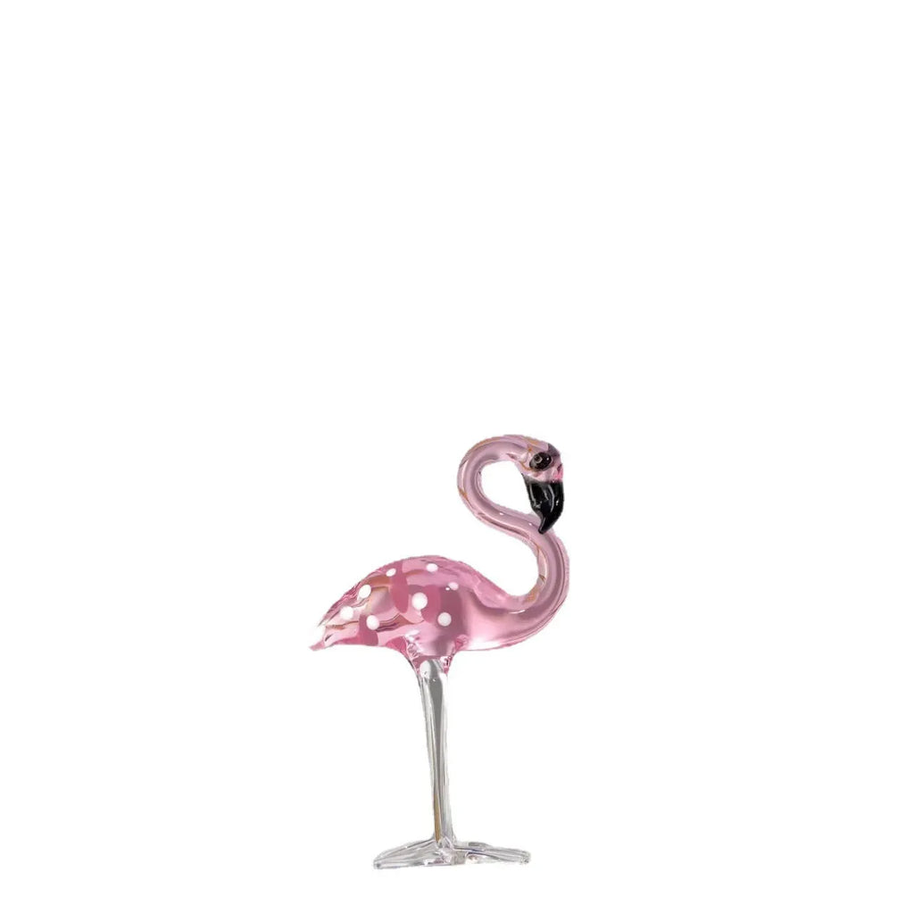 A pink flamingo decorative ornament made from clear white crystal on a table.