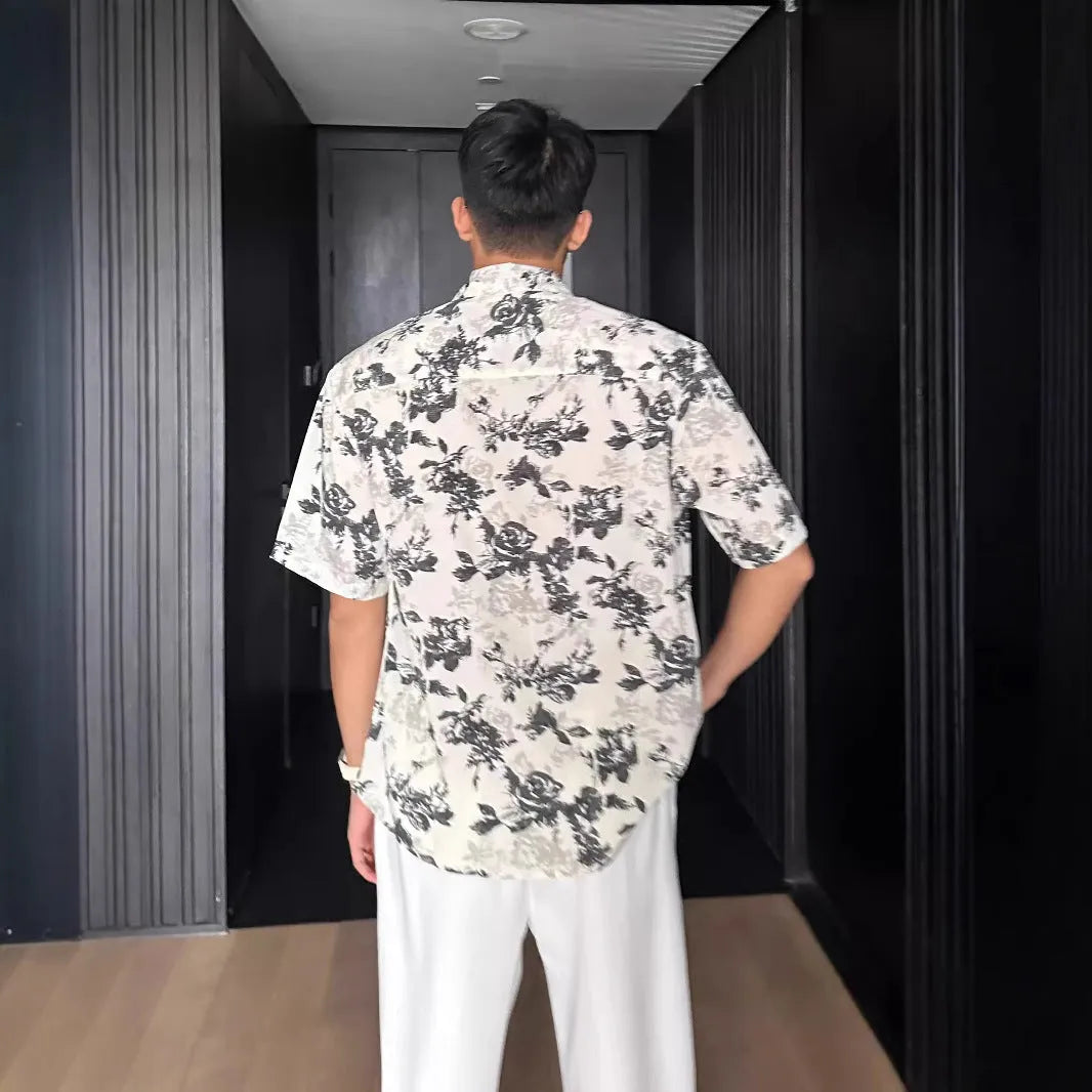 Men's loose-fit black short sleeve shirt with a white floral print pattern.