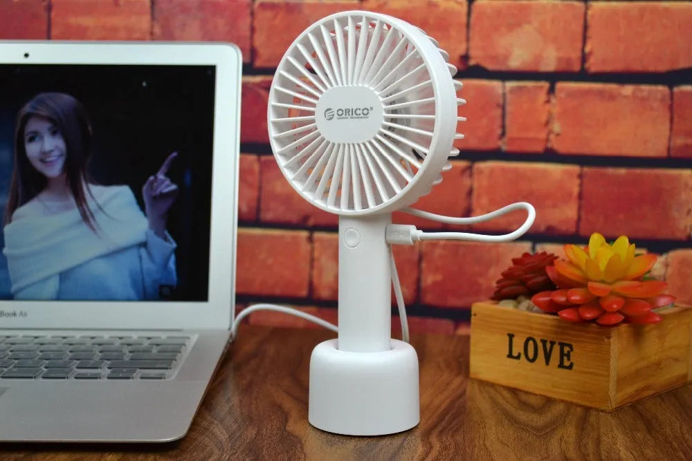 White ORICO FH1 portable USB rechargeable desk fan with three-speed buttons and a fine line pattern on its ABS shell.